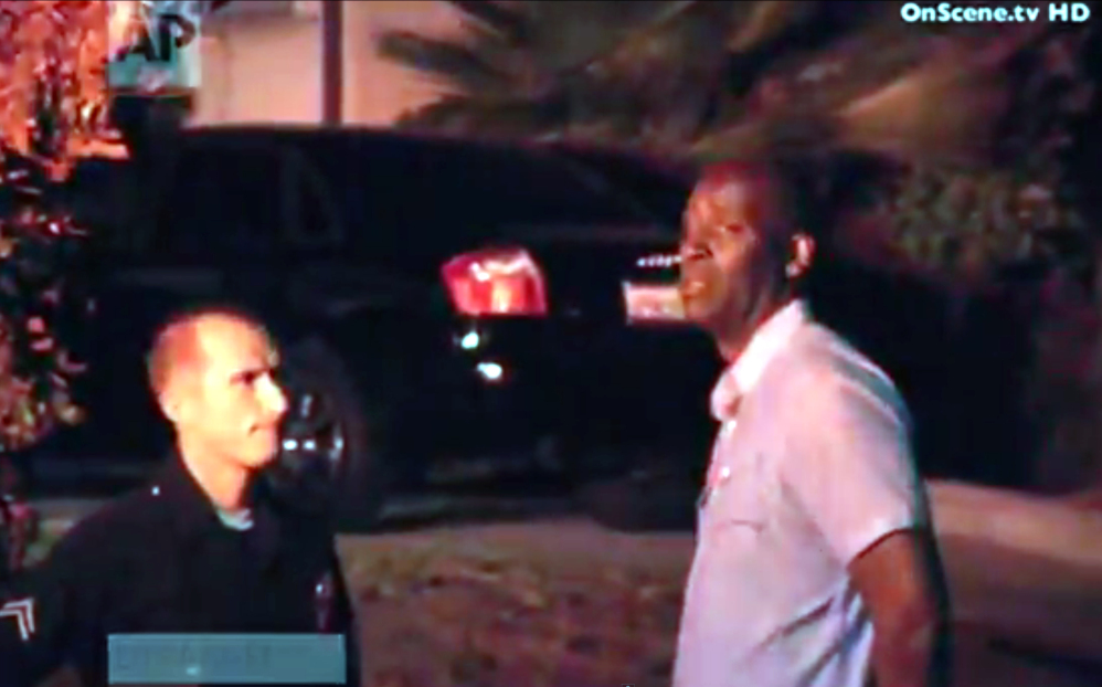 In this image taken from video from OnScene.tv, actor Michael Jace, right, is detained by police outside his home in Los Angeles on Monday night. Jace, who played a police officer on the hit TV show "The Shield," was arrested on suspicion of homicide.