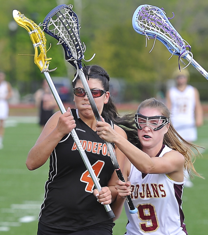 Katherine Dumoulin of Biddeford, left, is pressured by Carly McKenna of Thornton Academy while trying to move in Thursday during Thornton’s 11-2 victory at Saco.