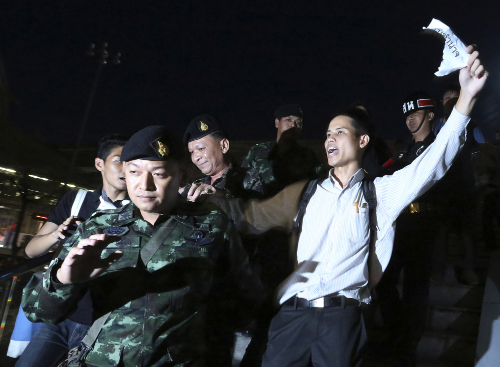 Thai soldiers detain Apichat Pongsawat, right, an activist who staged a protest against the coup in downtown Bangkok, Thailand, on Friday.