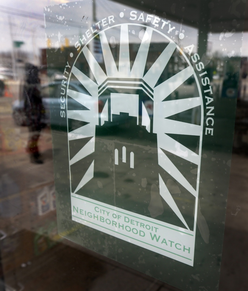 A decal highlighting shelter, safety and assistance is displayed on the front door of Mousa Bazzi’s Mobil station on Detroit’s east riverfront.