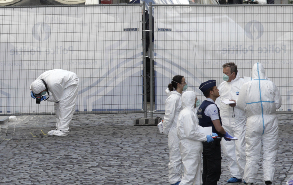 Forensic experts examine the site of a shooting at the Jewish museum in Brussels on Saturday. Belgian officials say that at least three people have been killed in gunfire at the Jewish Museum in Brussels.