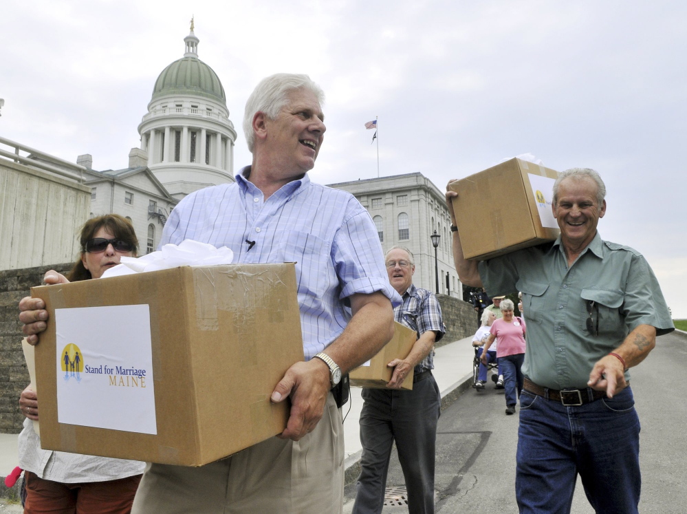 Bob Emrich, left, is shown delivering signatures collected by Stand for Marriage Maine to the secretary of state. Emrich, who helped run the 2009 and 2012 ballot committees that National Organization for Marriage dollars helped fund, said those donors should be protected. “People are targeted for harassment for contributing to a cause they believe in,” he said.