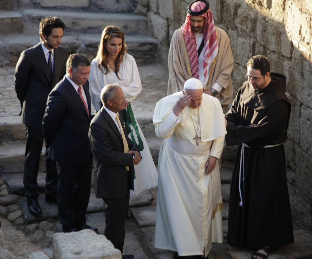Pope Francis makes the sign of the cross at the holy water at the Bethany beyond the Jordan, which many believe is the traditional site of Jesus’ baptism, in South Shuna, Jordan, on Saturday. Accompanying the pontiff are King Abdullah II of Jordan, Queen Rania and members of their family.