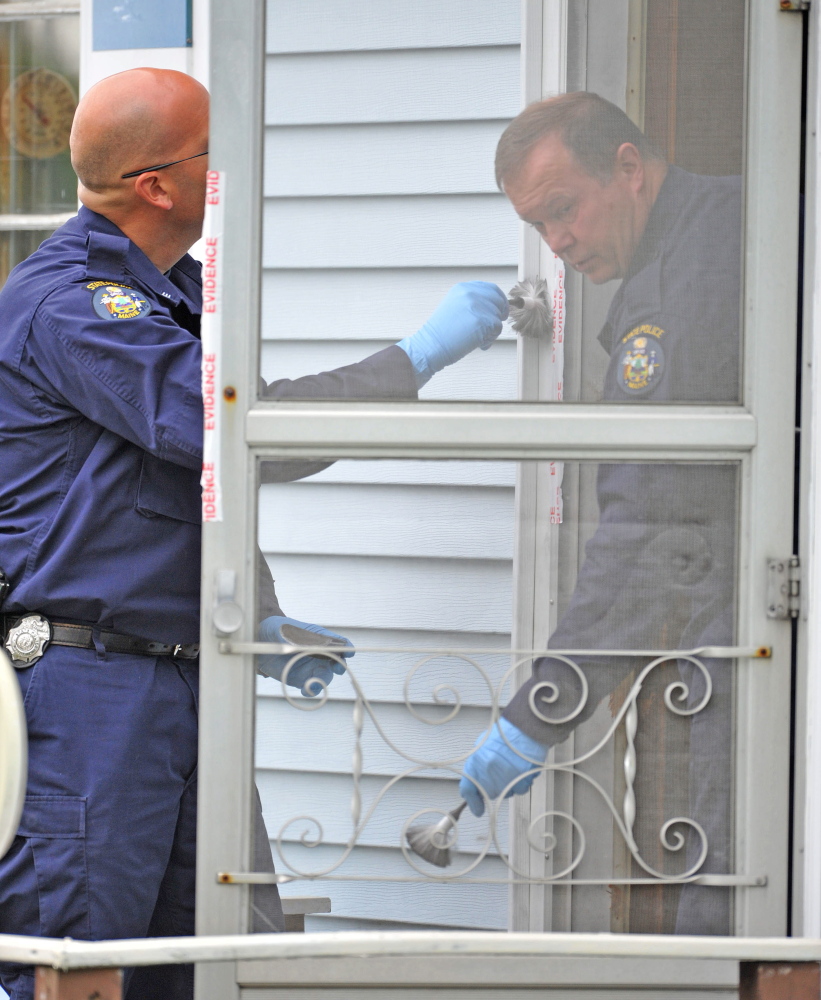 An investigator with the Maine State Police Major Crimes Unit dusts for fingerprints at the residence of Aurele Fecteau, 92, who was found dead in his home on Brooklyn Street in Waterville on Friday.