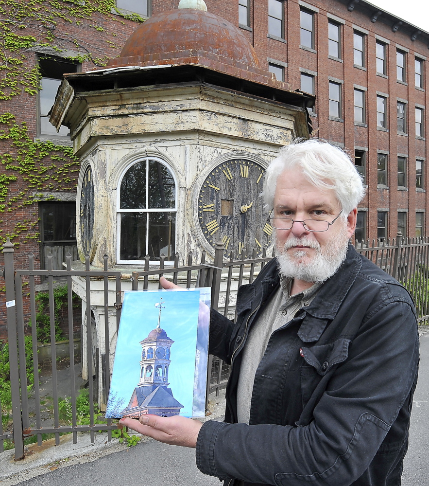 Historian George Collord of Portland shows an image of the original condition of the clock tower in this May 2014 photo.