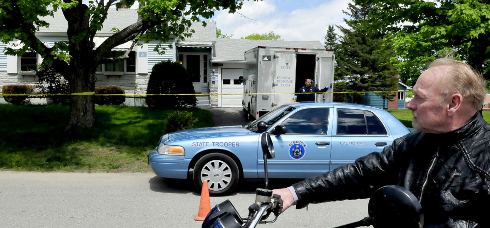 Paul Fecteau watches as a Maine State Police detective exits a Maine State Police Major Crime Unit vehicle outside the cordoned-off home of his father, Aurele Fecteau, in Waterville on Sunday. Aurele Fecteau was found dead by his elder brother Ernest on Friday, according to Paul Fecteau. The death was ruled a homicide on Sunday.