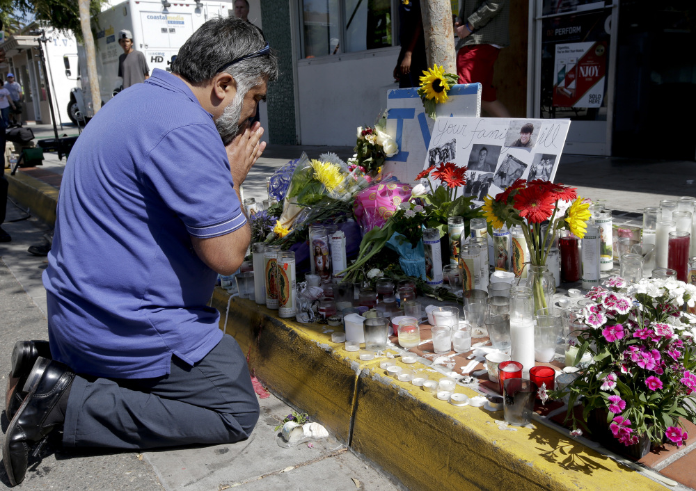 Jose Cardoso pays his respects Sunday at a makeshift memorial in front of the IV Deli Mart, scene of part of Friday night’s mass killing in the Isla Vista area near Goleta, Calif. Seven people died in the rampage, including the killer, 22-year-old Elliot Rodger.