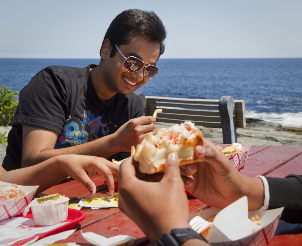 Yogesh Kauntia enjoys good friends and good food at the Lobster Shack at Two Lights in Cape Elizabeth as part of his Memorial Day weekend in Maine on Sunday.