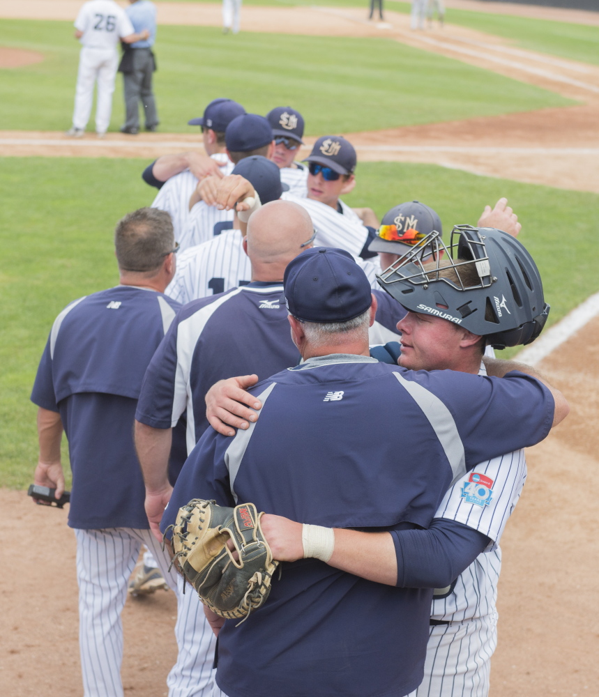 University of Southern Maine’s catcher Matt Verrier gets a hug after being removed from the game with other seniors in the ninth inning Monday in Appleton, Wis.
