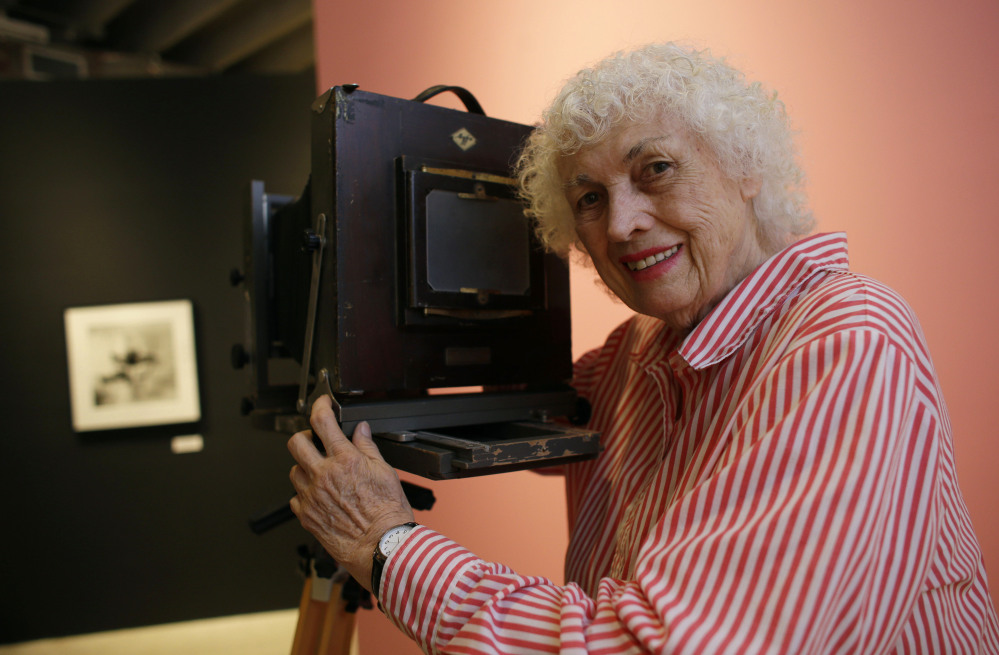 Bunny Yeager poses in April 2013 with a camera similar to one used when she worked as a photographer in the 1950s and ’60s at the Bunny Yeager Studio in Miami.