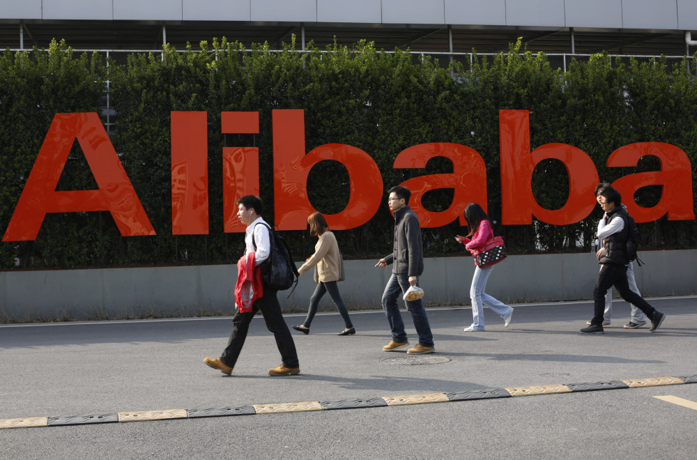People walk past a company logo at the headquarters of Alibaba Group in Hangzhou, in eastern China’s Zhejiang province.
