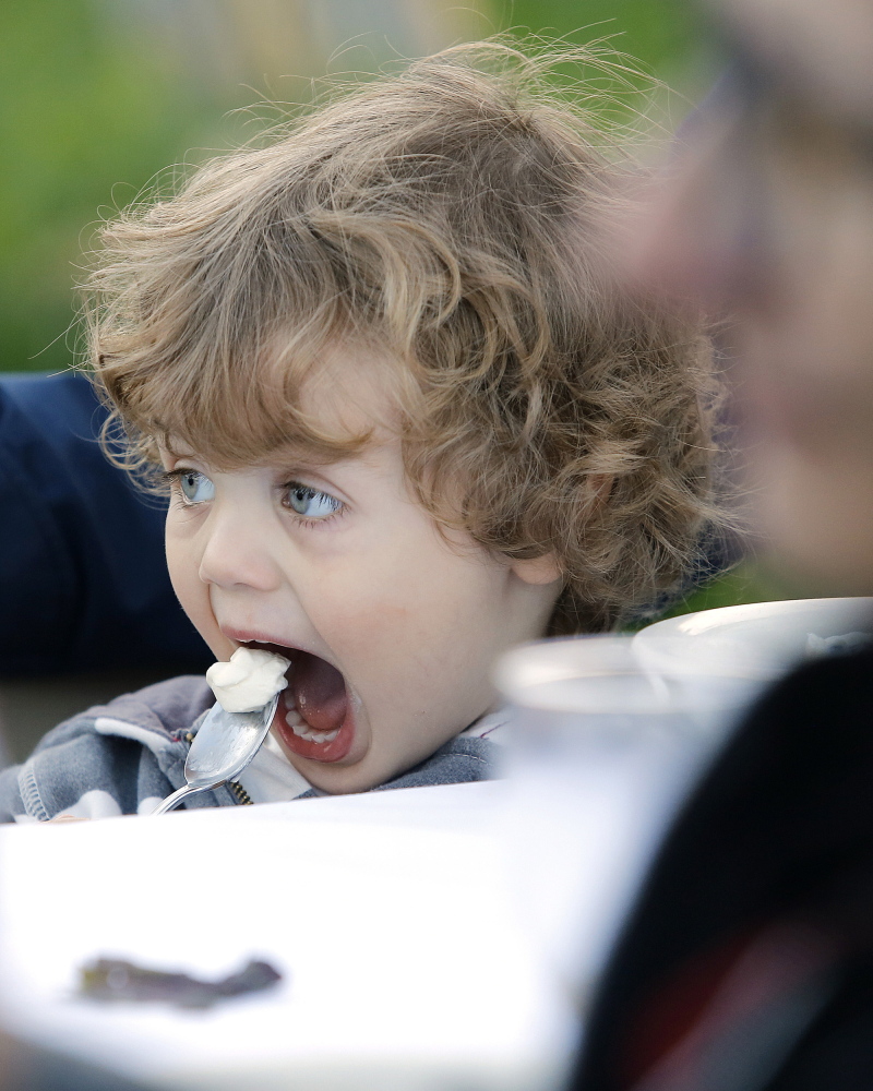 Marek Osucha-Middleton, 2, of Lewiston digs into some dessert during a "performative dinner" at Nezinscot Farm.