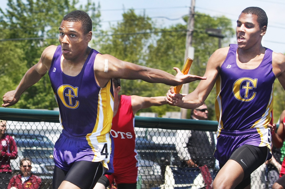 Elijah Yeboah, right, of Cheverus hands the baton to his twin brother, Isaac, in the 400-meter relay at the SMAA meet. The brothers helped Cheverus win both the 400 and 1,600 relays, and Isaac also swept the two hurdle races as the Stags won the team title.