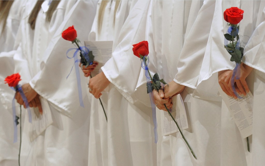 Female members of Portland High School's Class of 2013 hold roses during the graduation ceremony at Merrill Auditorium Thursday, June 6, 2013.