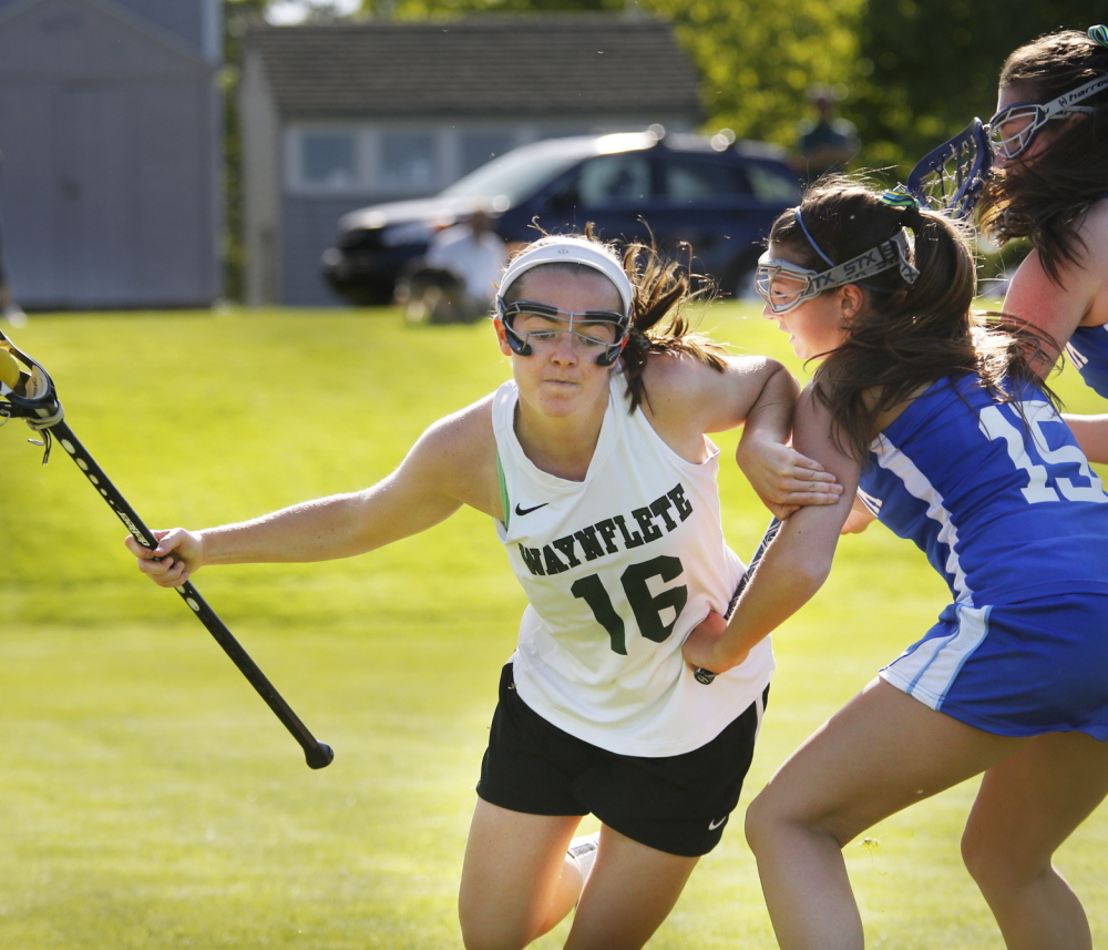 Leigh Fernandez, who scored the game-winning goal in the third overtime for Waynflete, tries to create space Thursday while being defended by Haley Fecko, left, and Kyra Schwartzman of Kennebunk. Waynflete won, 7-6. Photo by Derek Davis/Staff Photographer