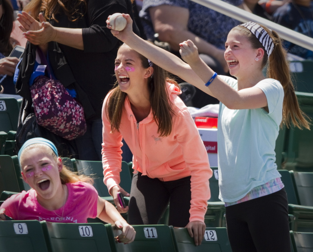 Jane Greenberg, right, celebrates after catching a foul ball during Education Day at the Portland Sea Dogs game at Hadlock Field Thursday. She was joined by friends Sydney Michelson, center, and Mia Kelley,  left. The girls are from Scarborough. Carl D. Walsh/Staff Photographer