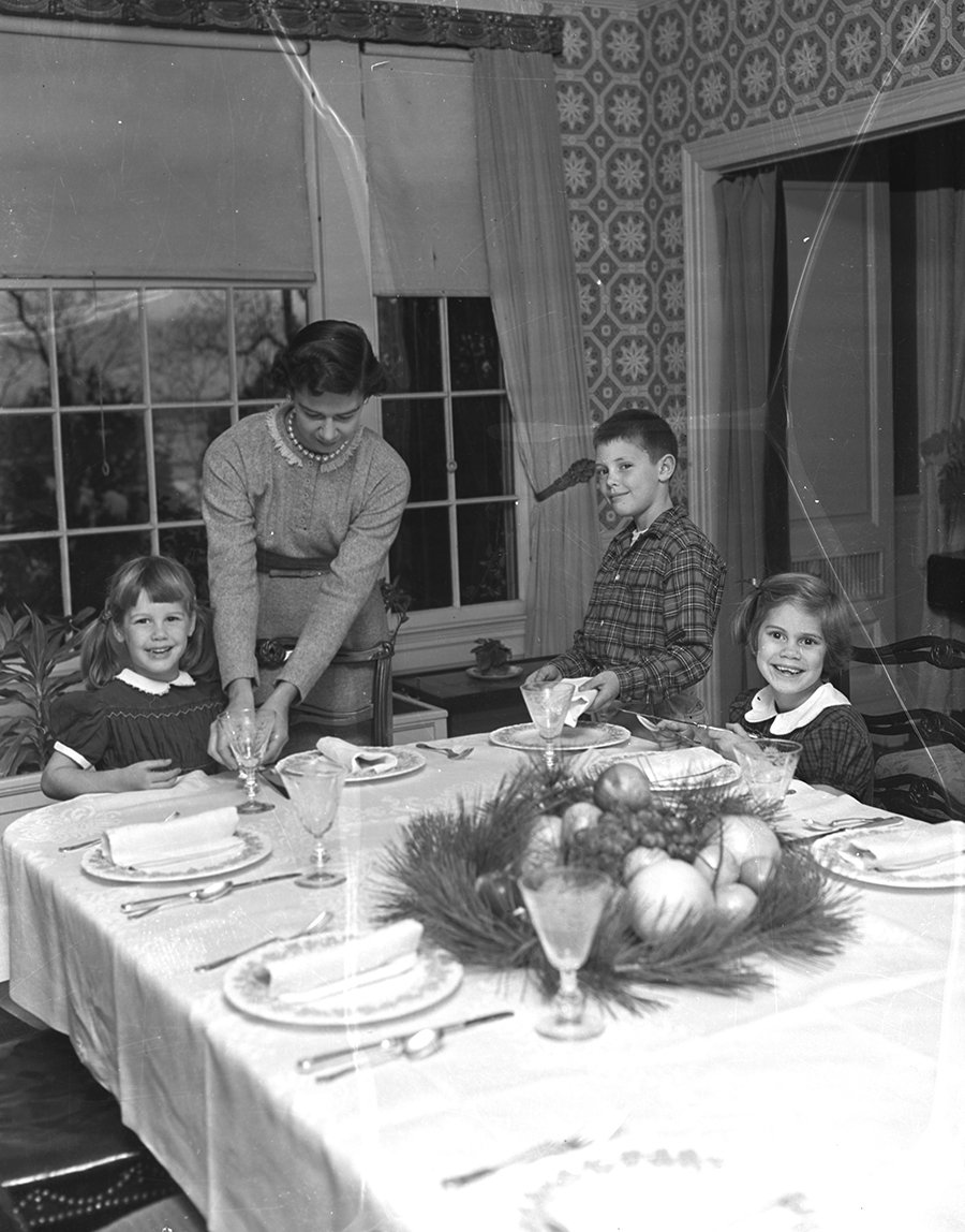 Preparing for a large holiday dinner group are the family of Dr. Howard R. Ives of Bowdoin St., left to right: Cindy, 4, Mrs. Ives, Rollin, 8, and Sally, 7.