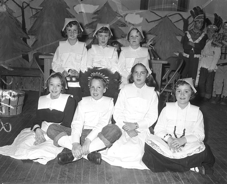 From the Thursday, Nov. 22, 1956 Portland Press Herald, page 27. Original caption: 'Several members of the cast of the Thanksgiving play given yesterday in Butler School are, seated, left to right, Kay Holt, John Huack, Matha Moulton and Patricia Strout. Standing, left to right, Sally Heflin, Joanne McDonough and Deborah Pierce.'