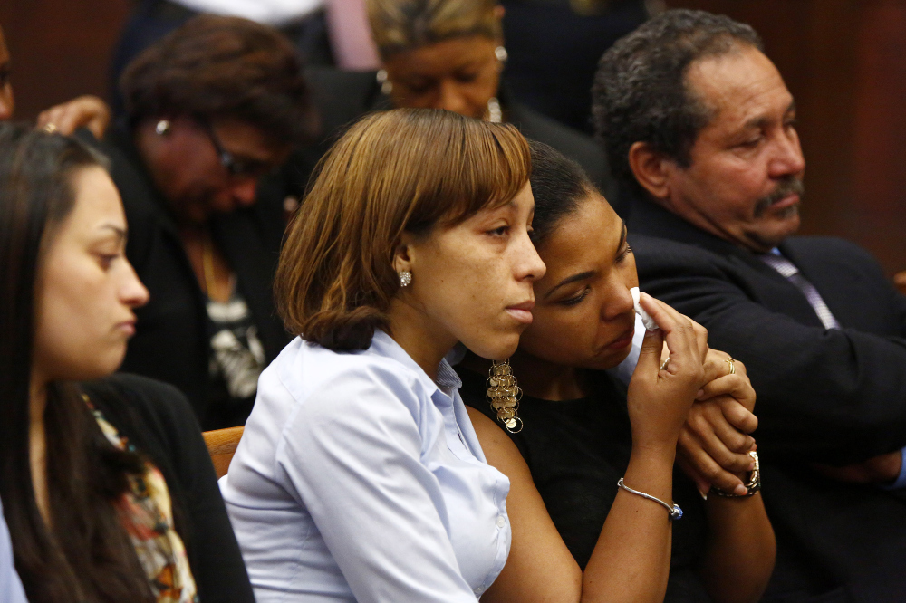 People identified as a victimâs family members react as they wait for former New England Patriots player Aaron Hernandez to appear at Suffolk Superior Court in Boston on Wednesday. The Associated Press