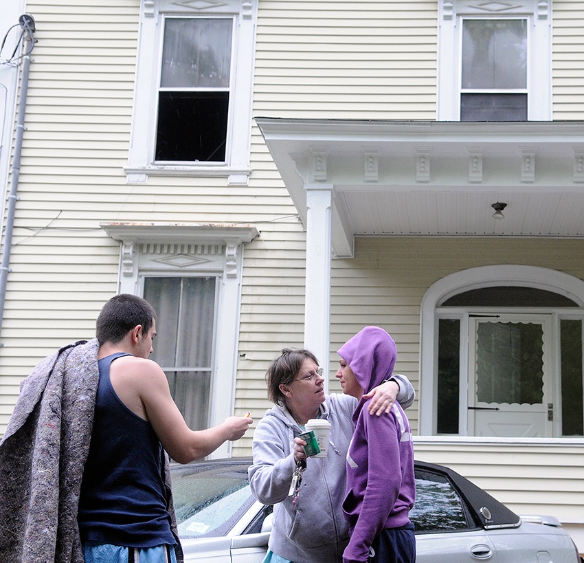 Jackie Nelson, center, hugs her granddaughter, Sabrina Moulton on Tuesday, May 27, 2014, after an early morning fire forced them to evacuate the apartment building Moulton owns at 11 Cedar Court Street in Augusta along with tenant Anthony Luczkowski. The blaze that was reported at 5:30 a.m. injured the occupant of the apartment where the fire was contained, according to Augusta Deputy Fire Chief David Groder.