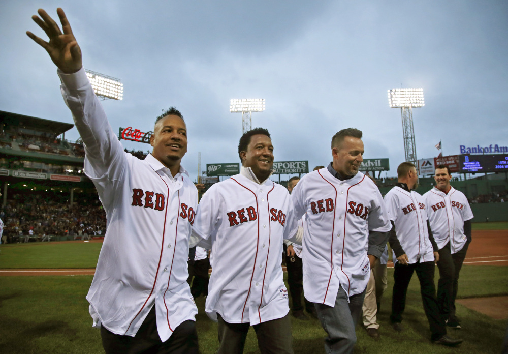 Former Boston Red Sox players, from left, Manny Ramirez, Pedro Martinez and Kevin Millar leave the field after they celebrated with teammates from 2004 at Fenway Park prior to a baseball game against the Atlanta Braves in Boston, Wednesday, May 28, 2014. The Red Sox honored the 10th anniversary of the 2004 World Series team before the game. The Associated Press/Elise Amendola