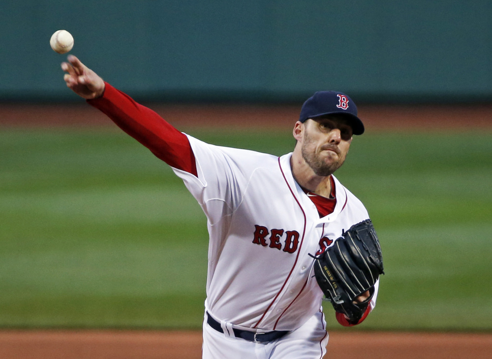 Boston Red Sox starting pitcher John Lackey delivers to the Atlanta Braves in the first inning of a baseball game at Fenway Park in Boston, Wednesday, May 28, 2014. The Associated Press/Elise Amendola