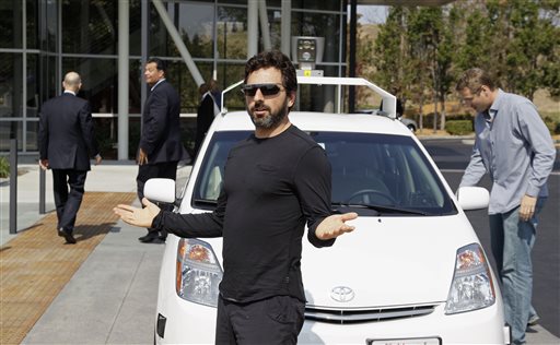In this Sept. 25, 2012, file photo, Google co-founder Sergey Brin gestures after riding in a driverless car with officials, to a bill signing for driverless cars at Google headquarters in Mountain View, Calif. Google engineers say they have turned a corner in their pursuit of creating a car that can drive itself. Test cars have been able to navigate freeways comfortably for a few years. On Monday, April 28, 2014, Google said the cars can now negotiate thousands of urban situations that would have stumped them a year or two ago.  