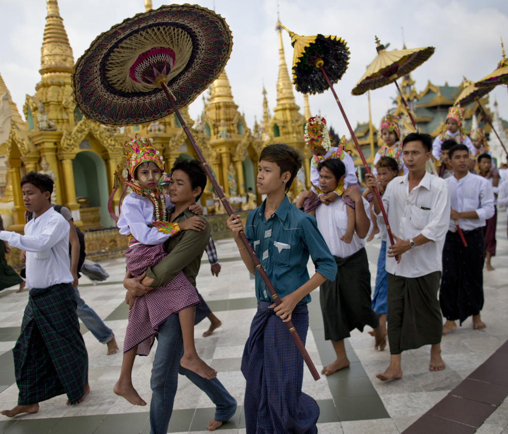Buddhist men carry their sons and nephews at the Shwedagon pagoda in Yangon, Myanmar, in April. The government views a religious conversion bill as politically sensitive. The Associated Press