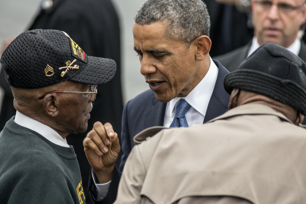 President Barack Obama talks with World War II veterans Sanders Matthews Sr., born 1921, left, and Lewis Coffield, born 1918, both Buffalo Soldiers, at Stewart Air National Guard Base in Newburgh, N.Y., Wednesday after delivering the commencement address at the United States Military Academy at West Point. The Associated Press