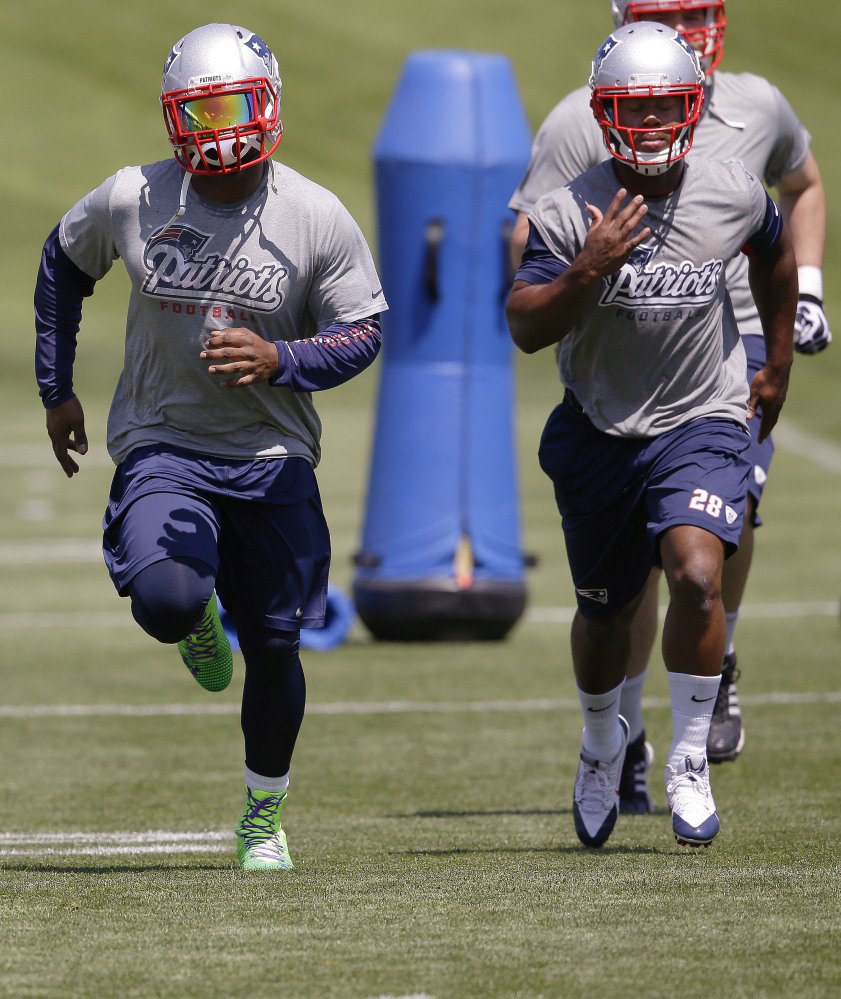 New England Patriots rookie running back James White (28) and running back Stevan Ridley run while stretching  during an organized team activity at the NFL football teamâs facility Friday, May 30, 2014 in Foxborough, Mass. The Associated Press/Stephan Savoia