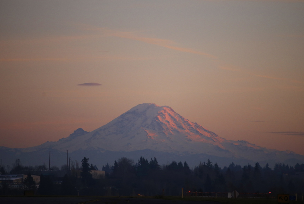 Mount Rainier is pictured as the last rays of sunlight hit its western side November 24, 2013. Two guides and their four clients are considered missing after they neither returned on schedule nor have communicated since the reached an altitude of 12,800 feet. The Associated Press