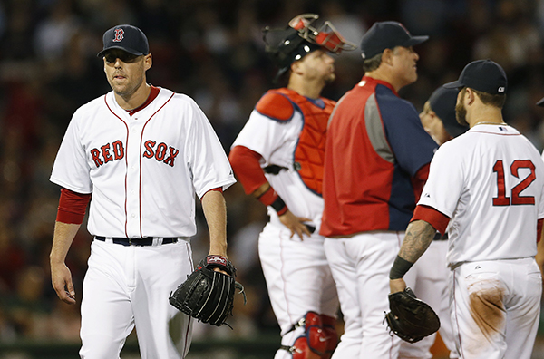 Boston Red Sox's John Lackey, left, walks to the dug out after being taken out by manager John Farrell, second from right, in the sixth inning of a baseball game against the Detroit Tigers in Boston, Saturday, May 17, 2014. The Associated Press