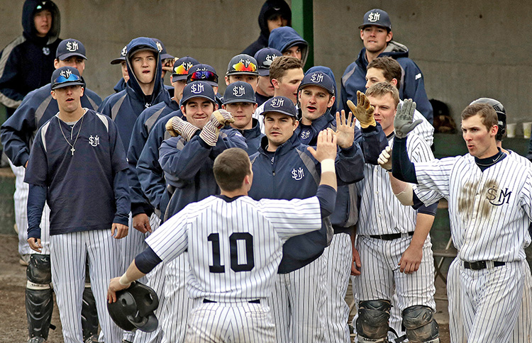 USM's Troy Thibodeau is greeted with high fives after knocking a solo home run in the bottom of the fourth inning vs. Bowdoin in a Division III game April 18, 2014.