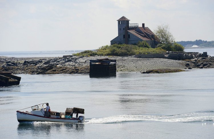 A lobster boat motors past the Wood Island Life Saving Station in Kittery in this 2012 photo.  Restoration of the station is slated to start this spring and could be done by the end of the summer. 