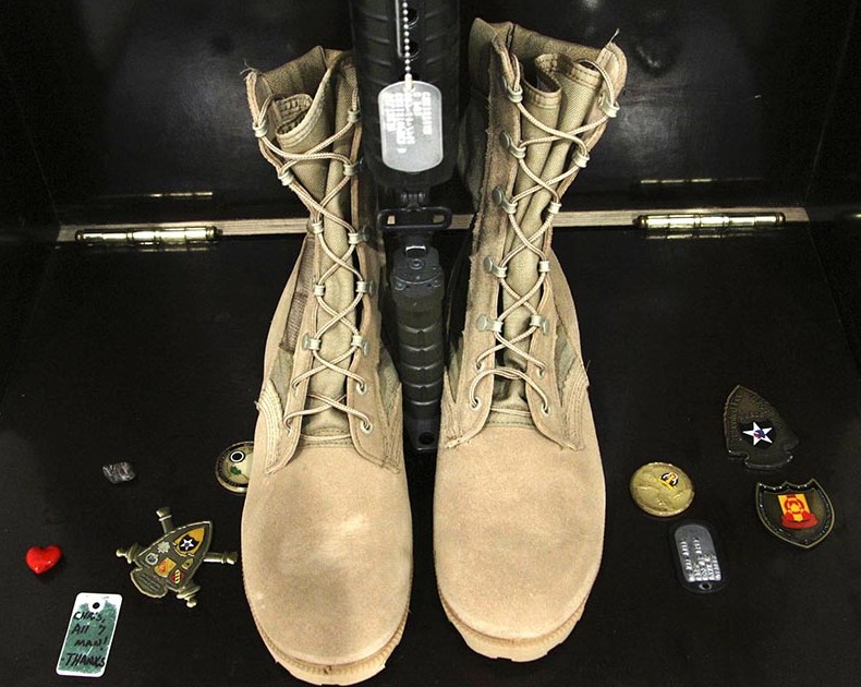 In this file photo medals and other items surround the boots of Christopher Gelineau. The items were left by soldiers of the 133rd Engineer Battalion as they paid their last respects at the end of a memorial service. 2004 Telegram File Photo/Gregory Rec