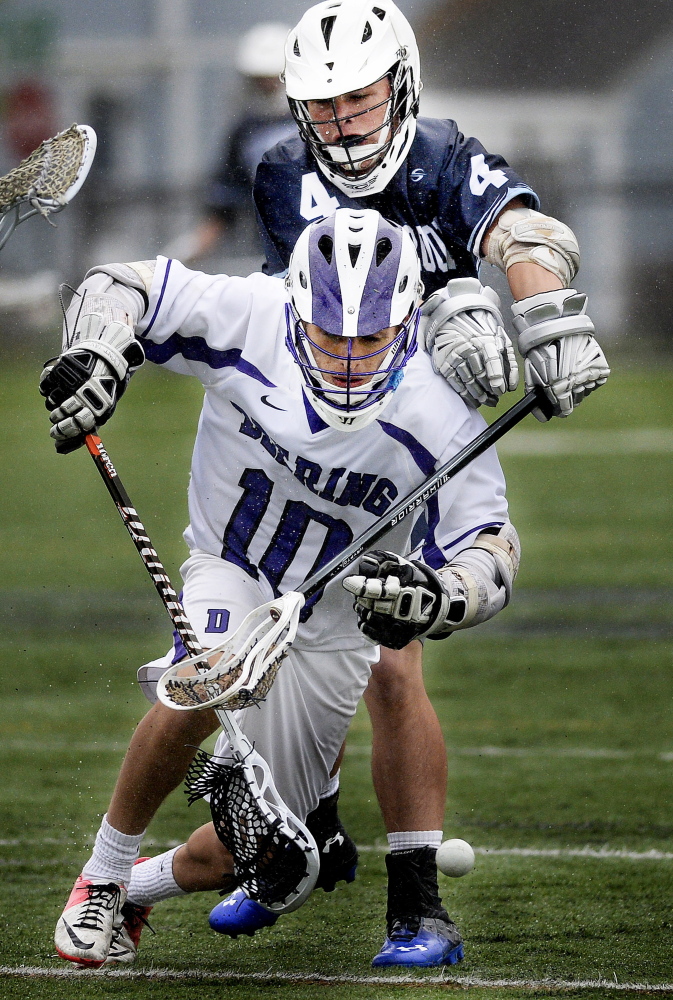 Sam Carroll of Westbook uses his stick to knock the ball away from Christian Castaneda of Deering.