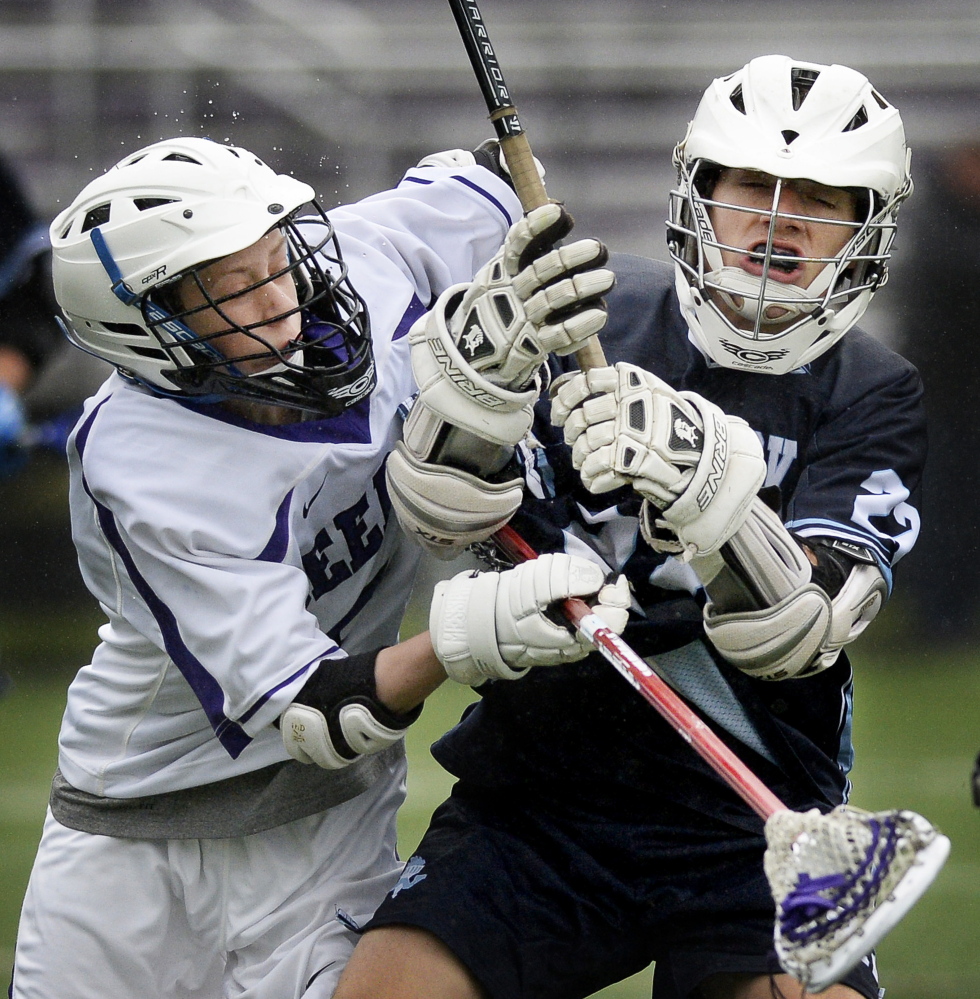 Photos by Shawn Patrick Ouellette/Staff Photographer Chase Walter of Deering, left, puts a check on Tyler Jack of Westbrook during their schoolboy lacrosse game Wednesday. Westbrook earned a 22-5 victory.