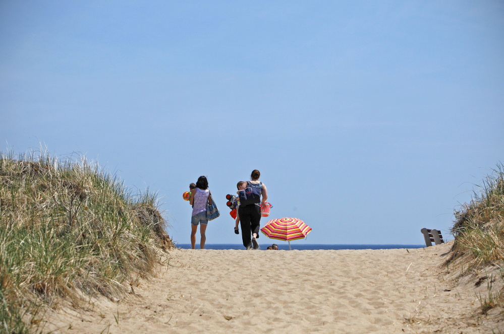 A family heads for the sand at Old Orchard Beach last month, on a day when temperatures climbed to near 80 degrees. Amelia Kunhardt/Staff Photographer