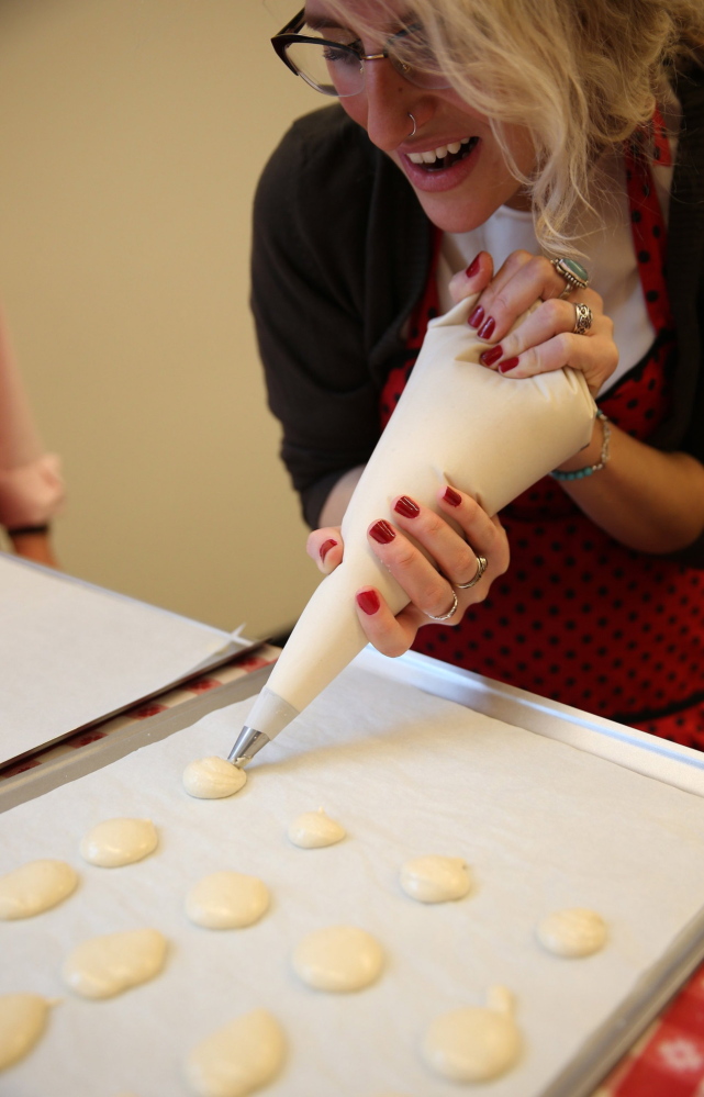 Heather Schroering uses a pastry bag to make her coffee- flavor macarons during class at the Alliance Francaise de Chicago.
