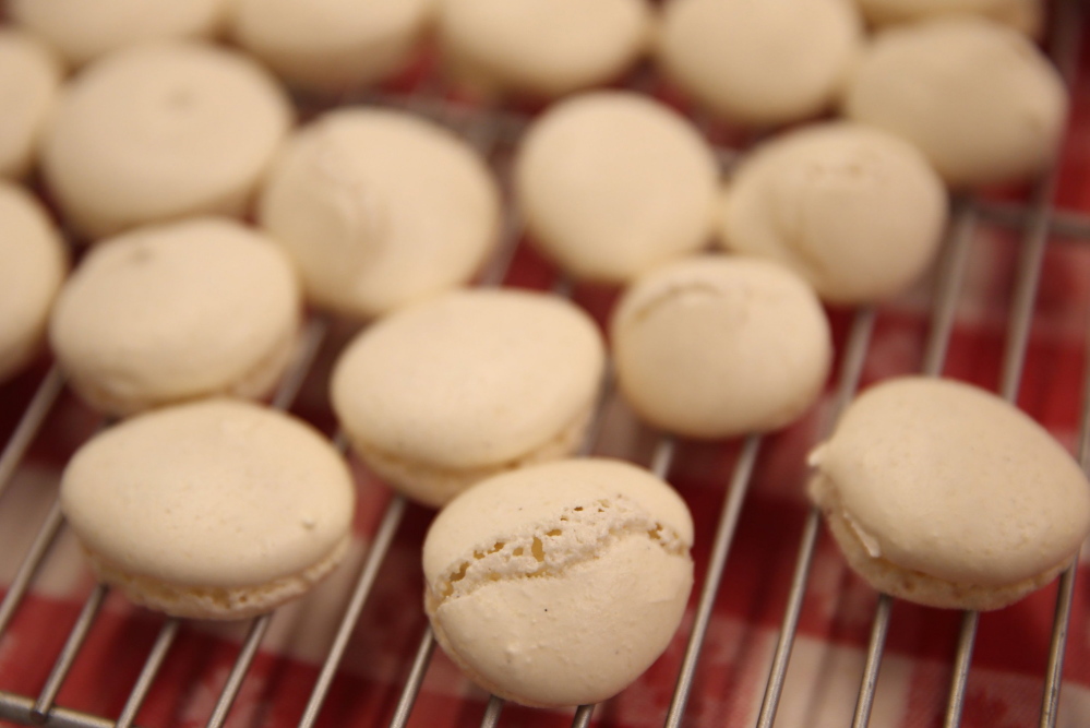 Macarons are delicate, cream-filled cookies that seem simple but can be difficult to get right. Bursting of the shell can be caused by air in the batter.