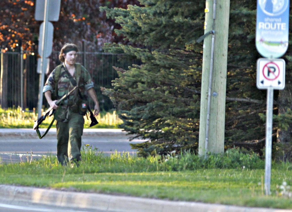 A heavily armed man whom police have identified as Justin Bourque walks on a street in Moncton, New Brunswick, on Wednesday after shots were fired in the area. The man is suspected of killing three Royal Canadian Mounted Police officers. The Associated Press/The Canadian Press, Moncton Times & Transcript, telegraphjournal.com, Viktor Pivovarov
