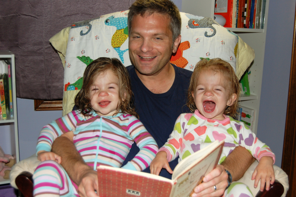 Mike Brandfon reads with his daughters Abby, left, and Sophie in Chicago. The number of U.S. fathers home with their kids full time for a variety of reasons is down from a peak 2.2 million in 2010, the official end of the recession, to about 2 million in 2012, according to a report released Thursday by the Pew Research Center. 2012 Photo/The Associated Press/Sara Brandfon