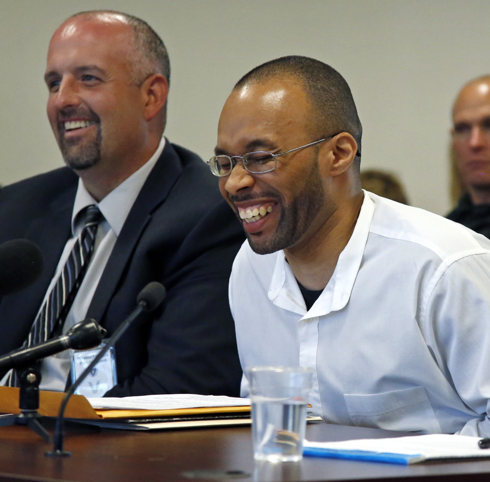 Imprisoned for 20 years, Frederick Christian, right, laughs during a light moment at a recent parole hearing in Natick, Mass. At left is his attorney Joe Mulhern. The Associated Press 