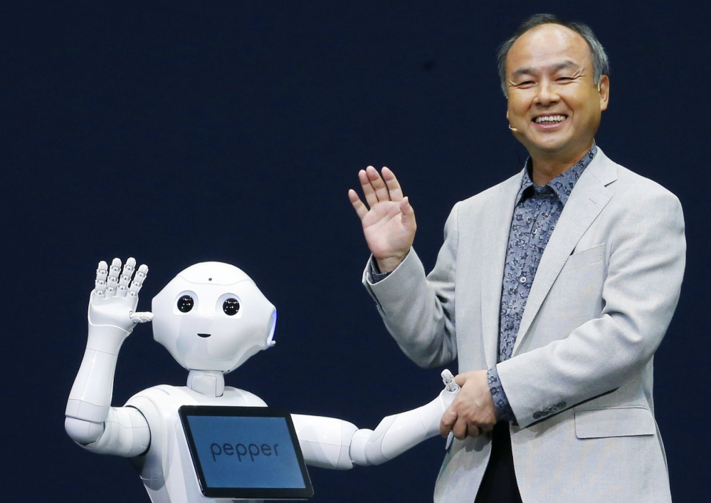 Softbank Corp. President Masayoshi Son and Pepper, a newly developed robot, wave together during a press event Thursday. The humanoid on wheels can decipher human emotions.
AP Photo/Kyodo News