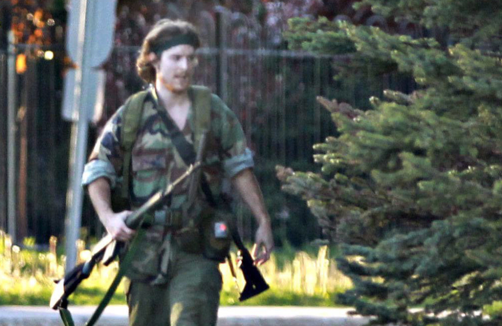 An armed man identified by police as Justin Bourque, suspected of killing three Royal Canadian Mounted Police officers, is seen in Moncton, New Brunswick. He was arrested early Friday. AP Photo/Moncton Times & Transcript, telegraphjournal.com, Viktor Pivovarov