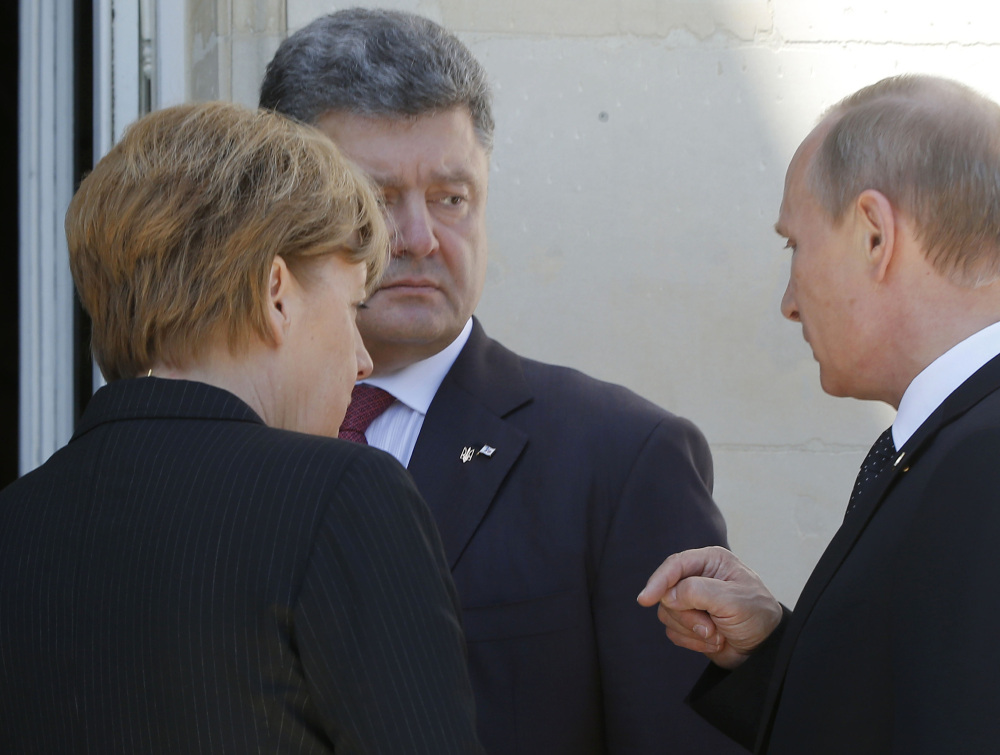German Chancellor Angela Merkel, left, Russian President Vladimir Putin, right, and Ukrainian president-elect Petro Poroshenko in Normandy. The Associated Press