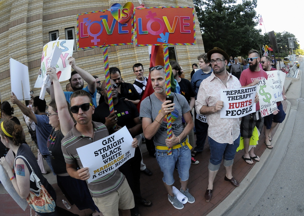 People hold signs during a same-sex marriage rally outside the Fort Worth Convention Center in Fort Worth, Texas, as the Texas Republican convention began Thursday. The Associated Press 