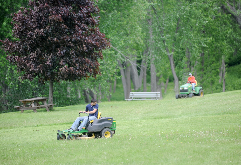 Winslow Parks and Recreation workers mow the grass at Fort Halifax Park in Winslow on Friday. Fort Halifax will host the Winslow Family 4th of July Celebration from July 2-4. Michael G. Seamans / Staff Photographer