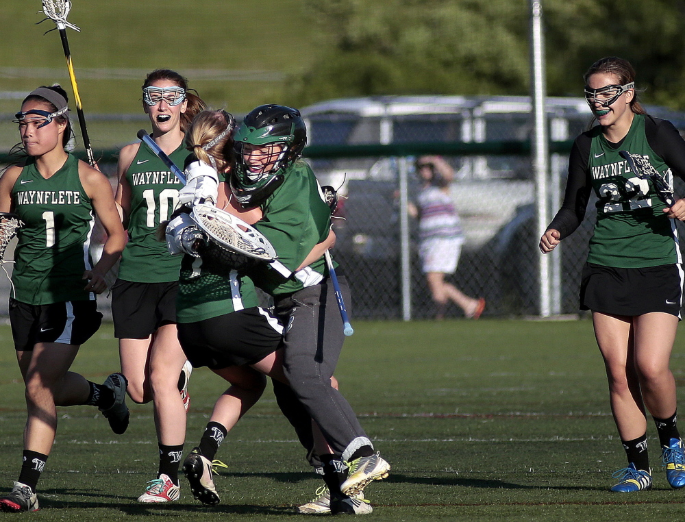 Waynflete’s Ellen Silk and goalie Charlotte Majercik, center, embrace as Helen Gray Bauer (1), Amelia Deady (10) and Dana Peirce (22) join the celebration Friday after a 10-5 win over Cape Elizabeth in a Western Maine Conference girls’ lacrosse season finale Friday. Gabe Souza/Staff Photographer