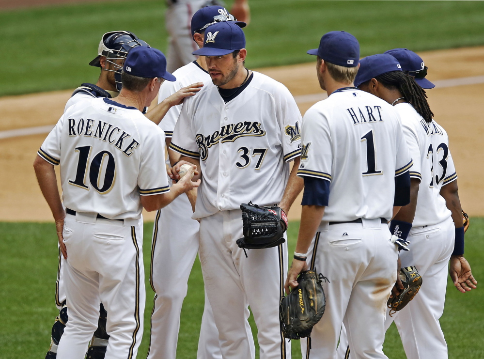 Mark Rogers, center, is removed by Brewers Manager Ron Roenicke in the sixth inning of a major league game in 2012. Two years later, Rogers’ promising moment as a big-league pitcher finds him pitching in an independent league team after arm problems led Milwaukee to cut ties with him. 2012 File Photo/The Associated Press